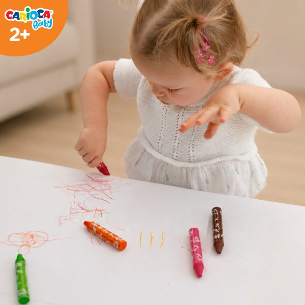 Dwuletnie dziecko rysujące grubymi kredkami Carioca Baby podczas ćwiczeń trzymania narzędzia i kontroli ruchu