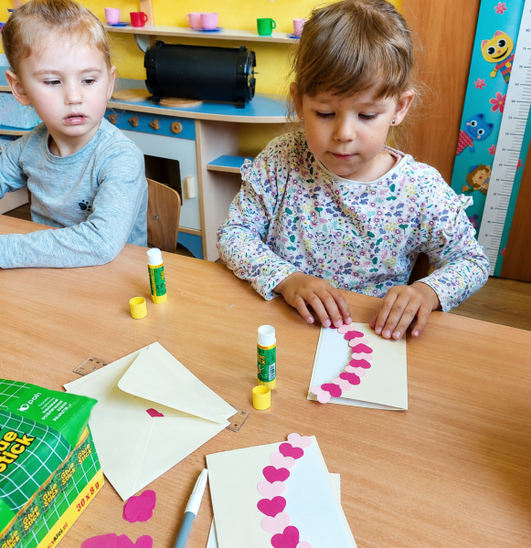 Dzieci w przedszkolu tworzą pracę plastyczną za pomocą kleju AMOS